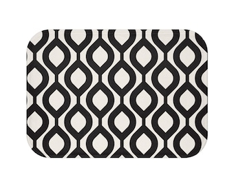 May include: Black and white geometric bath mat with a repeating pattern of interlocking ovals.