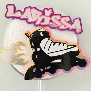 May include: A white cake topper with a black and white roller skate, yellow and silver flames, and the name "Larissa" in purple and pink letters.