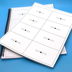 May include: A white booklet with a black spiral binding. The booklet has a grid of nine squares, each containing a row of five circles with a black dot in one of the circles.