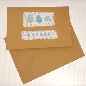 Pascua. Tarjeta de Pascua. Tarjeta de punto de cruz. Tarjeta hecha a mano. Arte con aguja. Felices Pascuas. Tarjeta con huevo de Pascua.