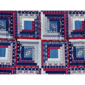 May include: A patchwork fabric featuring a repeating pattern of squares. Each square is composed of various rectangular shapes in red, white, and blue. Some squares have a central blue design with a paisley-like motif.