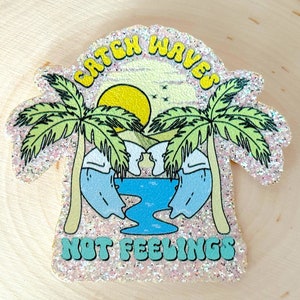 May include: A pink glitter sticker with a beach scene. Two palm trees with a yellow sun and blue waves. The text "Catch Waves Not Feelings" is written in green.