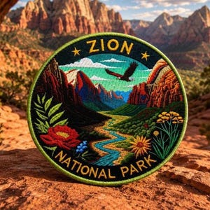 May include: A circular embroidered patch featuring a landscape of Zion National Park. The design includes red rock mountains, a winding blue river, a flying eagle, and colorful wildflowers. The text ZION NATIONAL PARK is stitched in yellow.