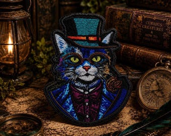 May include: An embroidered patch featuring a cat wearing a teal top hat with an orange band, round glasses, and a purple vest with a bowtie. The cat has bright yellow eyes and white whiskers, rendered in vibrant blue, purple, and teal thread colors.