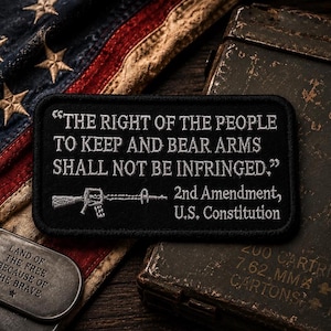 Peut inclure: Un écusson rectangulaire noir brodé avec le texte blanc THE RIGHT OF THE PEOPLE TO KEEP AND BEAR ARMS SHALL NOT BE INFRINGED, accompagné d'une icône de fusil et du texte 2nd Amendment, U.S. Constitution.