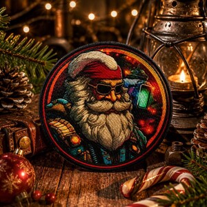 May include: Embroidered patch featuring Santa Claus wearing sunglasses and holding a lantern. The patch has a circular design with a red, black, and gold color scheme. Christmas-themed patch with a vintage aesthetic.