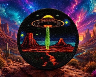 Può includere: Una toppa ricamata circolare che raffigura un cielo notturno scuro con un UFO giallo e arancione sopra un paesaggio desertico rosso. Un raggio di luce verde brillante si estende dal velivolo verso il suolo, circondato da stelle e pianeti.