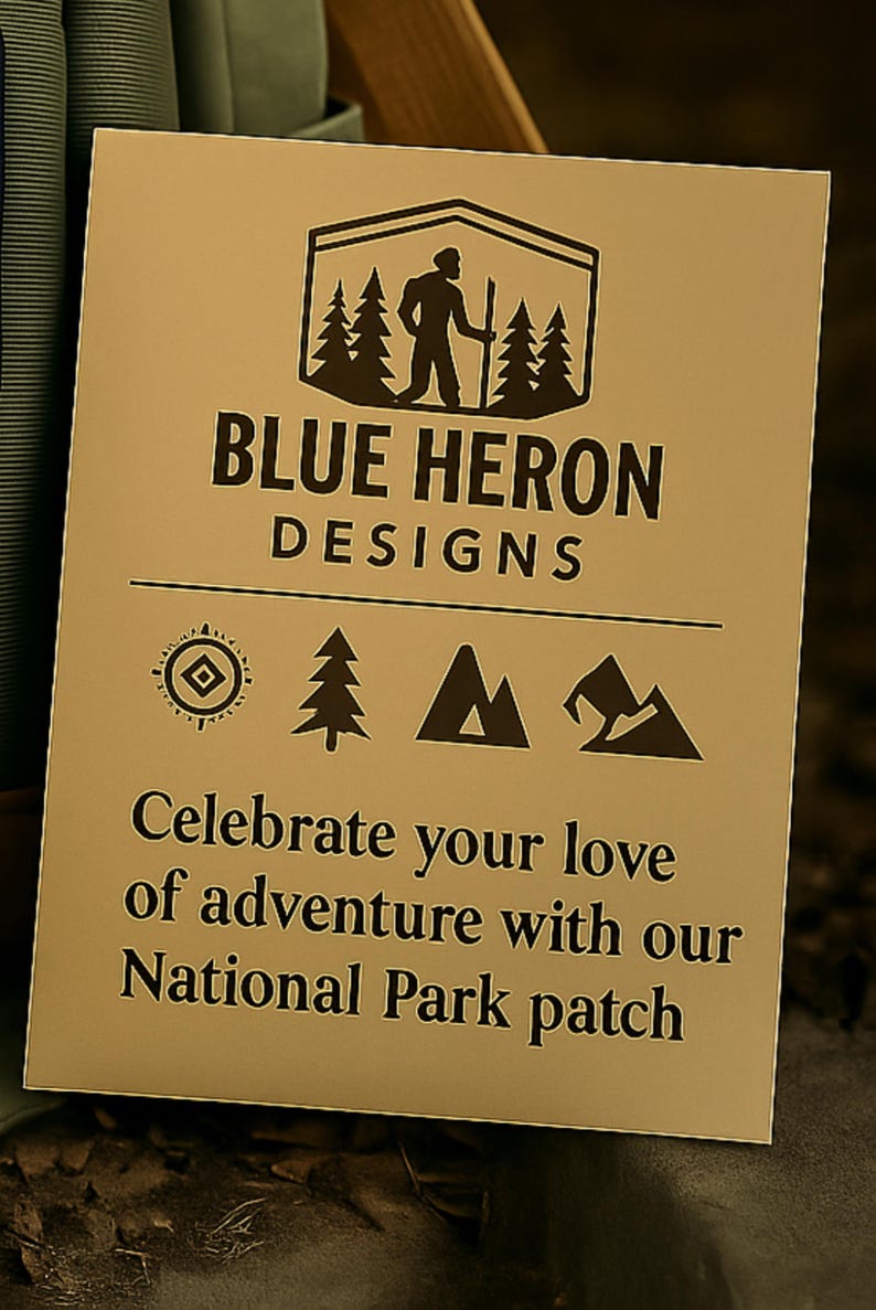 May include: A tan card with the text "BLUE HERON DESIGNS" and a logo of a person hiking in front of trees. The card also says "Celebrate your love of adventure with our National Park patch."