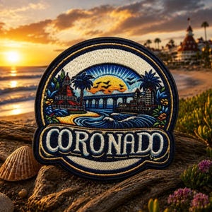 May include: Embroidered patch featuring a coastal scene with a lighthouse, bridge, and palm trees under a sunset sky. The patch is navy blue with the word "CORONADO" in a curved design.