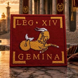 May include: A square red embroidered patch featuring a gold sea-goat in the center. The text LEG XIV is stitched in gold above the creature, and the word GEMINA is stitched in gold below, framed by gold corner brackets on a deep red fabric.