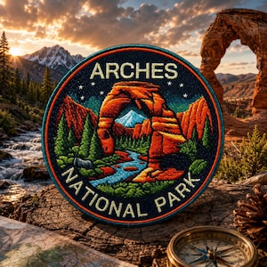 May include: Embroidered patch featuring the Arches National Park landscape. The circular patch displays the park's iconic arch, a river, and mountains, with the text "ARCHES NATIONAL PARK". The patch is set against a backdrop of a sunset, a map, and a compass.