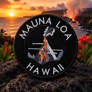 Może przedstawiać: Czarna okrągła naszywka z białym napisem "MAUNA LOA HAWAII" na krawędzi. Naszywka przedstawia grafikę wulkanu z pomarańczową lawą i szarym dymem. Tło przedstawia zachód słońca nad oceanem.