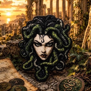 May include: A detailed embroidered patch featuring the face of Medusa with dark, coiled green snakes for hair. The design showcases a pale face with sharp, intense green eyes and dark lips, rendered in a high-contrast style with intricate thread work.