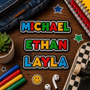 May include: Three rectangular embroidered patches with black borders featuring the names MICHAEL, ETHAN, and LAYLA in bold, multi-colored block letters. Each name uses a vibrant combination of blue, yellow, red, and green colors.