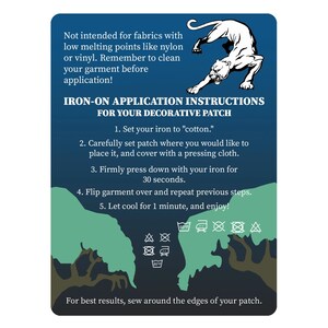 May include: A blue rectangular card with instructions for applying an iron-on decorative patch. The card features a white panther illustration and text detailing the application process, including ironing time and fabric care.