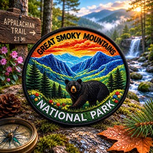 May include: Embroidered patch featuring a black bear in front of a mountain landscape with the text "Great Smoky Mountains National Park." The patch is round with a green border and colorful details. A sign for the Appalachian Trail is visible.