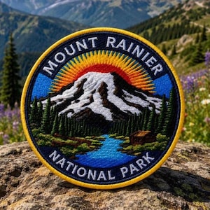 Peut inclure: Un écusson brodé circulaire représentant un sommet enneigé, une rivière bleue et des pins verts. Le ciel présente un soleil rayonnant jaune et orange. Le texte MOUNT RAINIER NATIONAL PARK est brodé en blanc le long de la bordure.