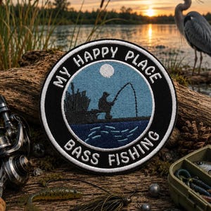 May include: A circular embroidered patch with a black border and white text reading "MY HAPPY PLACE" and "BASS FISHING". The center features a light blue sky with a white moon, a dark blue lake, and a silhouette of a person fishing by reeds.