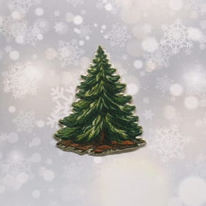 May include: A green embroidered felt Christmas tree patch with brown felt trunk and base. The patch is on a white background with a snowflake pattern.
