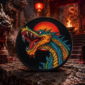 Peut inclure: Écusson brodé rond représentant une tête de dragon colorée sur fond noir avec un soleil rouge. Le dragon est jaune, bleu et vert. L'écusson est probablement en tissu et peut être cousu sur des vêtements.