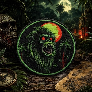 May include: A circular embroidered patch featuring a green, snarling primate with glowing red eyes set against a black background. The design includes a bright orange sun, palm trees, and a vibrant green border, creating a detailed jungle scene.