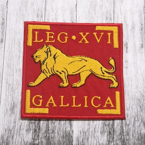 May include: A red embroidered patch with a yellow lion and the text "LEG XVI GALLICA" in yellow.