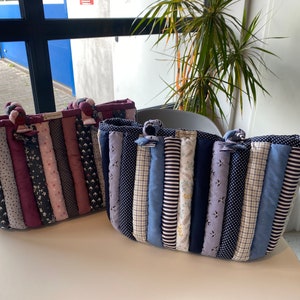 Peut inclure: Deux sacs cabas matelass&eacute;s faits de chutes de tissu. Le sac &agrave; gauche est fait de tissus roses, violets et noirs. Le sac &agrave; droite est fait de tissus bleus, blancs et noirs.