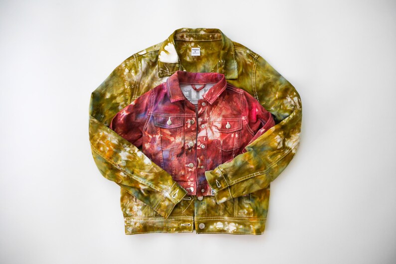 May include: Two denim jackets, one in a green and yellow tie-dye pattern and the other in a red and purple tie-dye pattern.