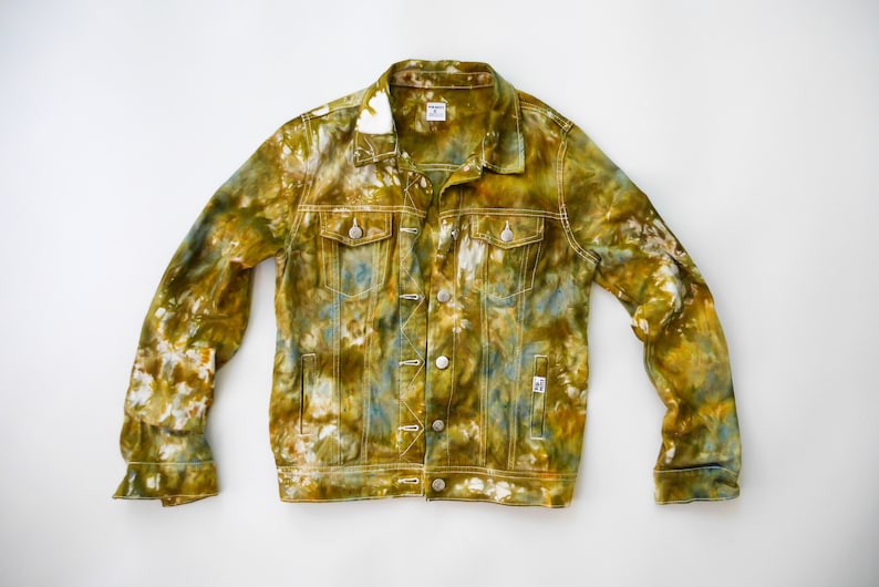 May include: A tie-dye denim jacket in shades of green, yellow, and blue. The jacket has a classic design with a button-up front and two pockets.