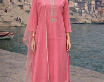 May include: A pink salwar kameez ensemble featuring a long tunic top, matching pants, and a sheer dupatta. The tunic has intricate embroidery around the neckline and down the center. The outfit is worn with sandals.