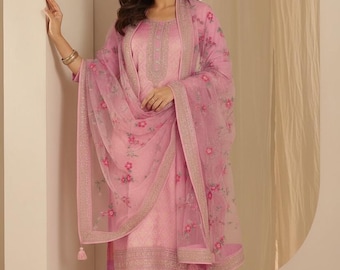 May include: A light pink salwar kameez ensemble. The outfit includes a tunic, matching pants, and a sheer dupatta with floral embroidery. The tunic features intricate embroidery around the neckline. The dupatta has a decorative border and tassels.