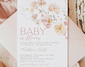May include: A pink baby shower invitation featuring floral illustrations. The text reads "BABY in bloom" and includes the name "Maddison Smith", the date "Saturday 17th May at 2pm", the address "145 Ventura Place Greenwood Portland Oregon", the phone number "Kayla 0123 456 789", and the registry information "registered at Amazon and Target".