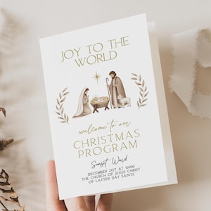 Könnte beinhalten: Ein gefaltetes Weihnachtsprogramm mit dem Text "JOY TO THE WORLD" in goldener Schrift. Das Programm zeigt eine Illustration der Krippenszene und den Text "welcome to our CHRISTMAS PROGRAM".