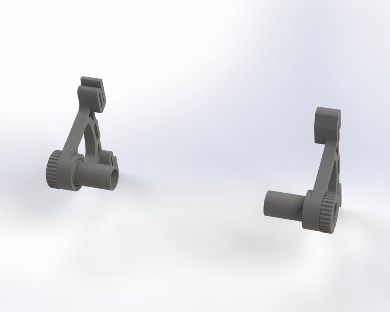 May include: Two gray plastic parts with a gear and a hole. The parts are designed to be connected together.