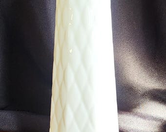May include: A tall, white vase with a diamond pattern. The vase has a narrow neck and a wider base. The surface of the vase has a glossy finish. The vase is likely made of ceramic or glass. The vase is suitable for displaying flowers.