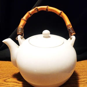 Vintage witte porseleinen theepot met houten handvat