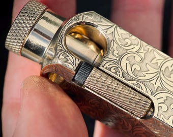 Isqueiro de edição limitada, robusto, estilo retrô vintage, em latão maciço dourado com detalhes ornamentados e gravuras.