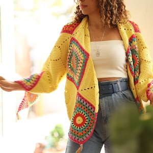Puede incluir: Un cárdigan de crochet amarillo con cuadrados de granny coloridos. El cárdigan tiene un corte holgado y una abertura delantera larga. Está hecho con un hilo suave y ligero y es perfecto para superponer.