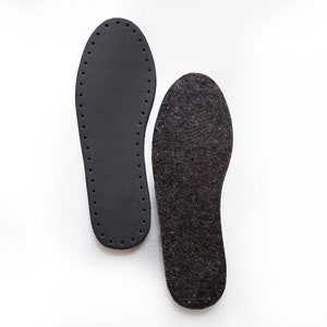 May include: Two black shoe insoles, one with a smooth surface and the other with a textured surface.