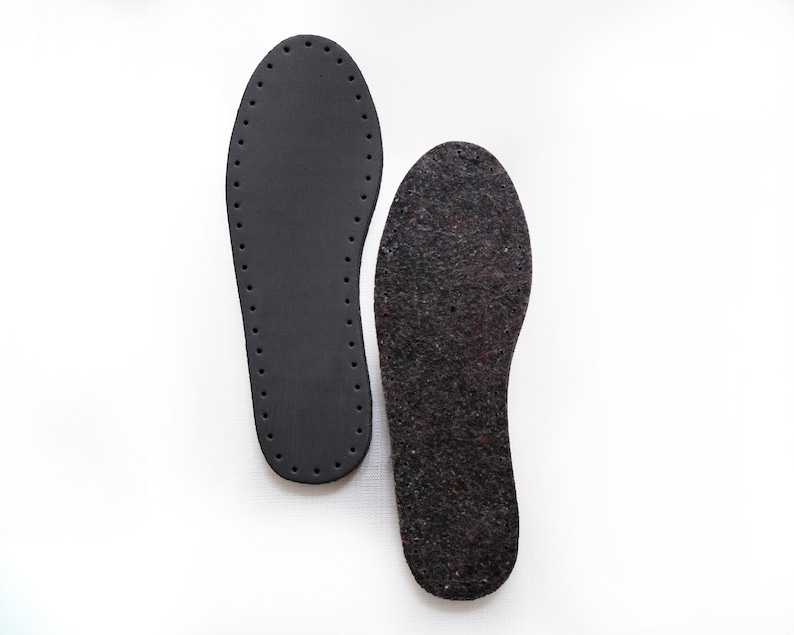 May include: Two black shoe insoles, one with a smooth surface and the other with a textured surface.