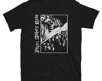 Puede incluir: Camiseta negra con un diseño gráfico blanco que presenta una multitud de caras y una figura esquelética. El texto "From Ashes Rise" está impreso verticalmente en el lado izquierdo de la camiseta en una fuente gótica.