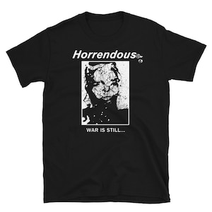 May include: Black t-shirt with a white graphic of a person's face with the text "Horrendous" and "War is still..."