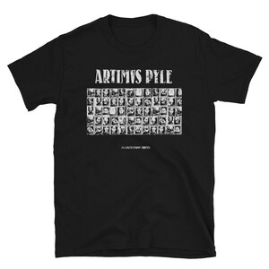 May include: Black t-shirt with white text that reads "ARTIMUS PYLE" and a grid of small images below the text. The text below the grid reads "FLICKED FROM BIRTH."