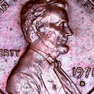May include: Close-up of a copper-colored 1978 Lincoln penny. The word "LIBERTY" is visible, along with the year and the letter "D". The coin features a profile of Abraham Lincoln.