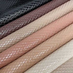 May include: Five rolls of quilted faux leather in various shades of brown, beige, and pink. The leather has a diamond-shaped pattern and a glossy finish.