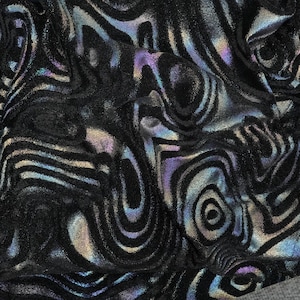 May include: Black fabric with a swirling iridescent pattern. The fabric has a subtle sheen and a textured surface.
