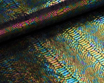May include: Close-up of iridescent black fabric with a snakeskin pattern. The fabric has a subtle sheen and a textured surface.
