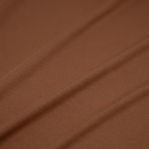 May include: A close-up of a brown fabric with a smooth texture. The fabric is folded and has a subtle sheen.