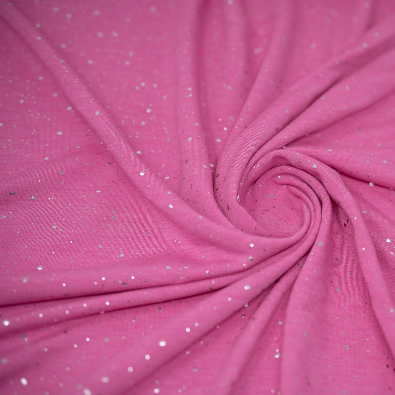 May include: Pink fabric with silver glitter throughout. The fabric is soft and has a subtle sheen.