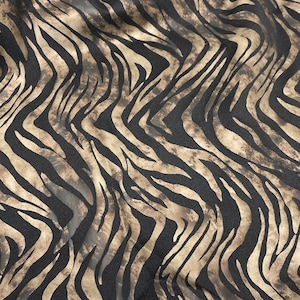 May include: Black and brown fabric with a zebra print pattern.